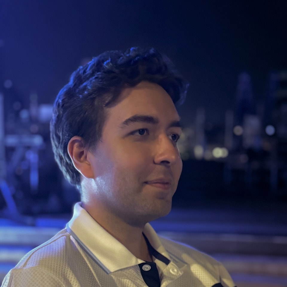Barış Girişmen in a light polo shirt against a blue-lit background